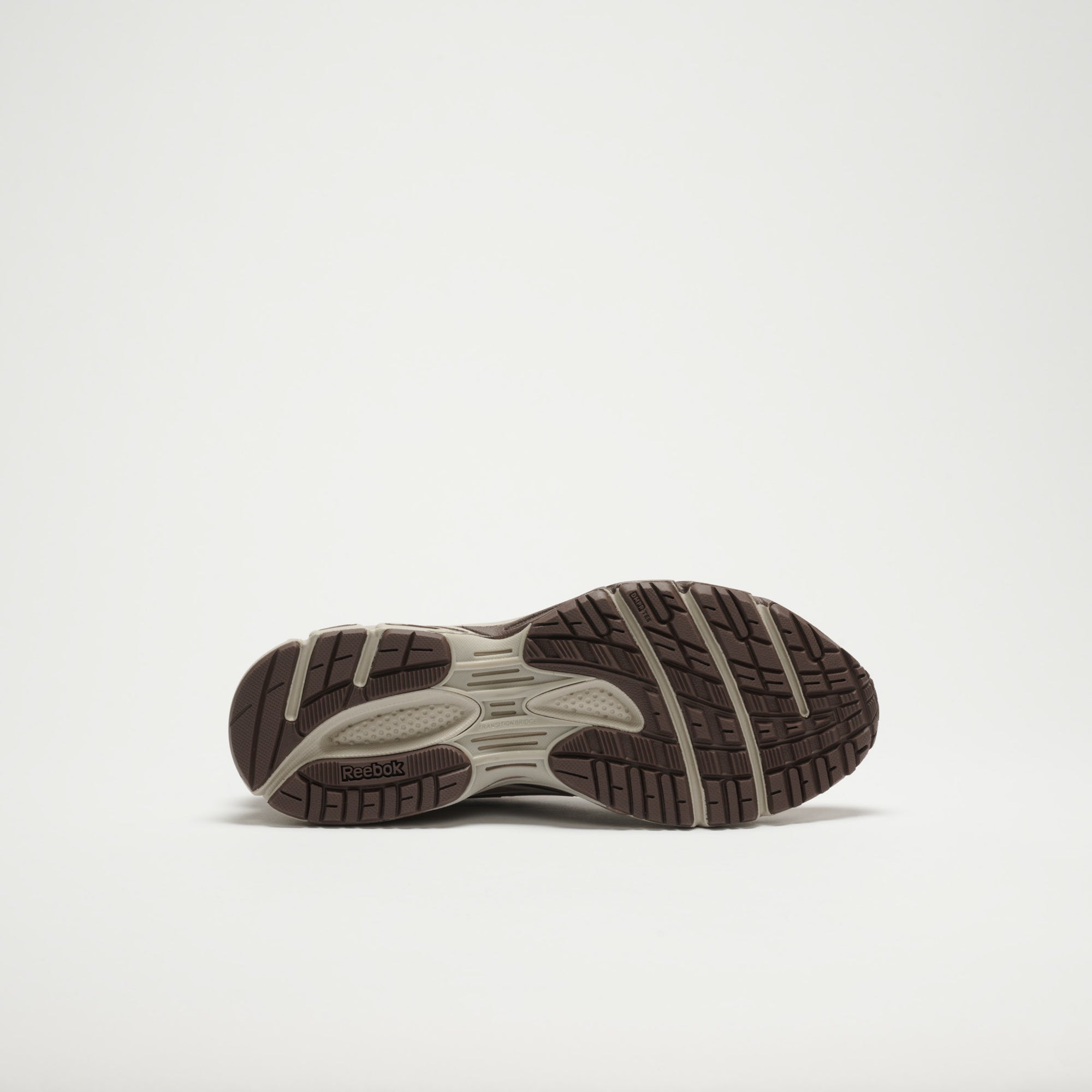 The image displays the sole of the Reebok Premier Road Modern LTD Shoes, featuring a brown and beige textured tread with the Reebok logo by the heel, captured against a plain white background.