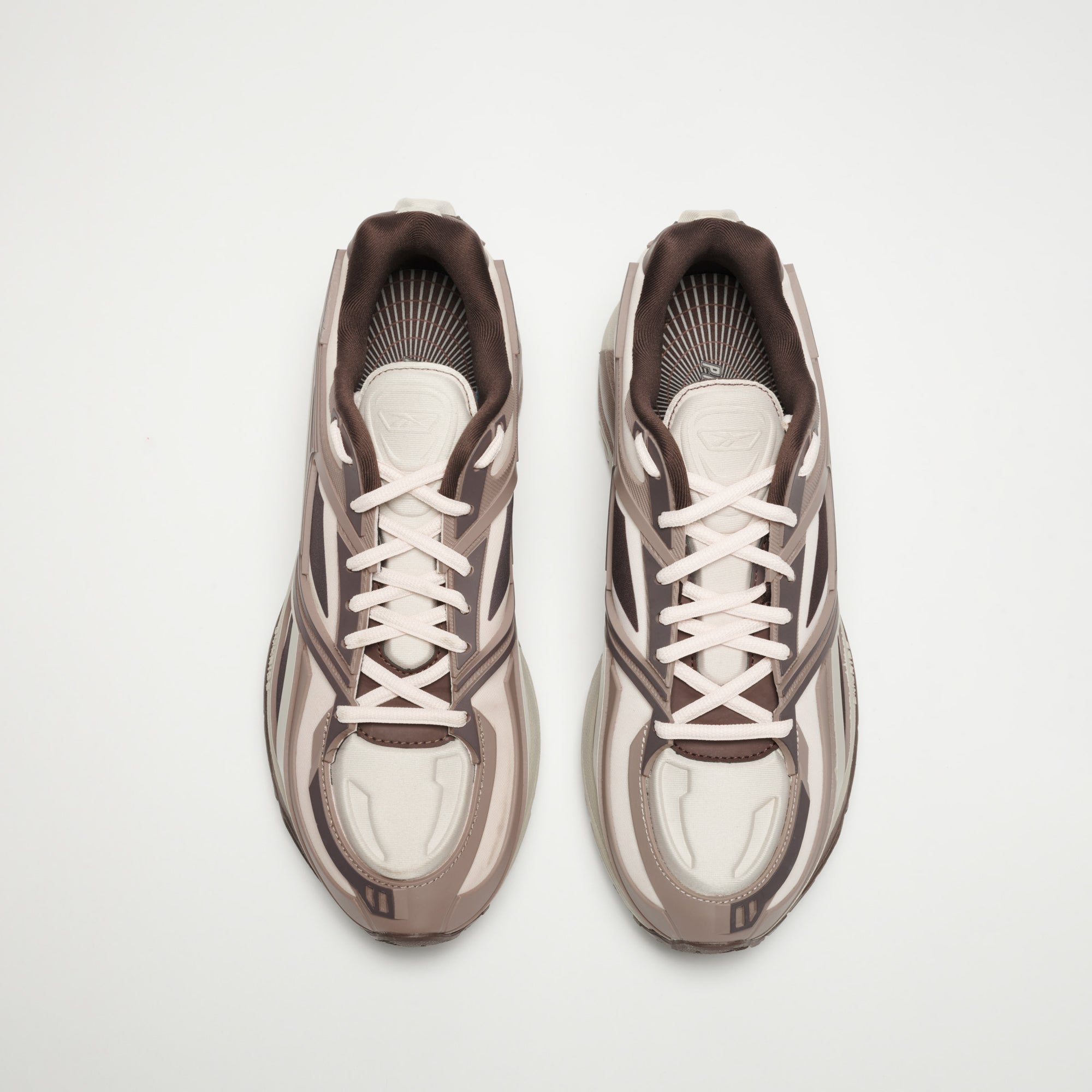 A pair of Reebok Premier Road Modern LTD Shoes in light beige and brown with white laces, seen from above on a plain white background.