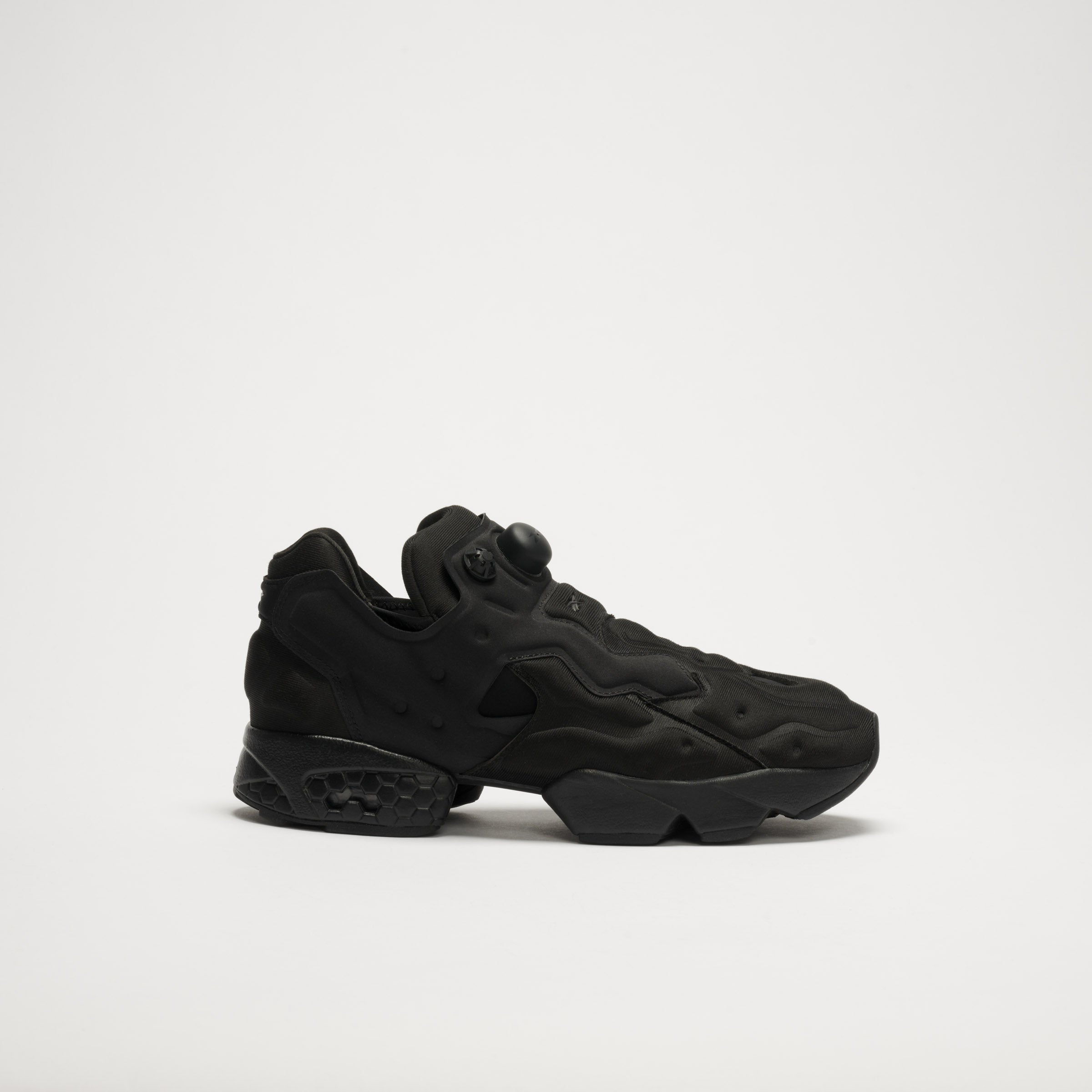 The Reebok Instapump Sliver LTD Shoes feature a futuristic black design with sculpted panels, a chunky sole with Hexalite cushioning, and an air pump system on the upper, displayed against a plain white background.