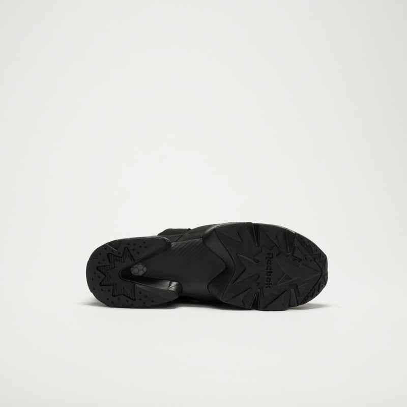 A black Reebok Instapump Sliver LTD Shoe rests on its side, showcasing the geometric-patterned sole and Hexalite cushioning, all set against a plain white background.