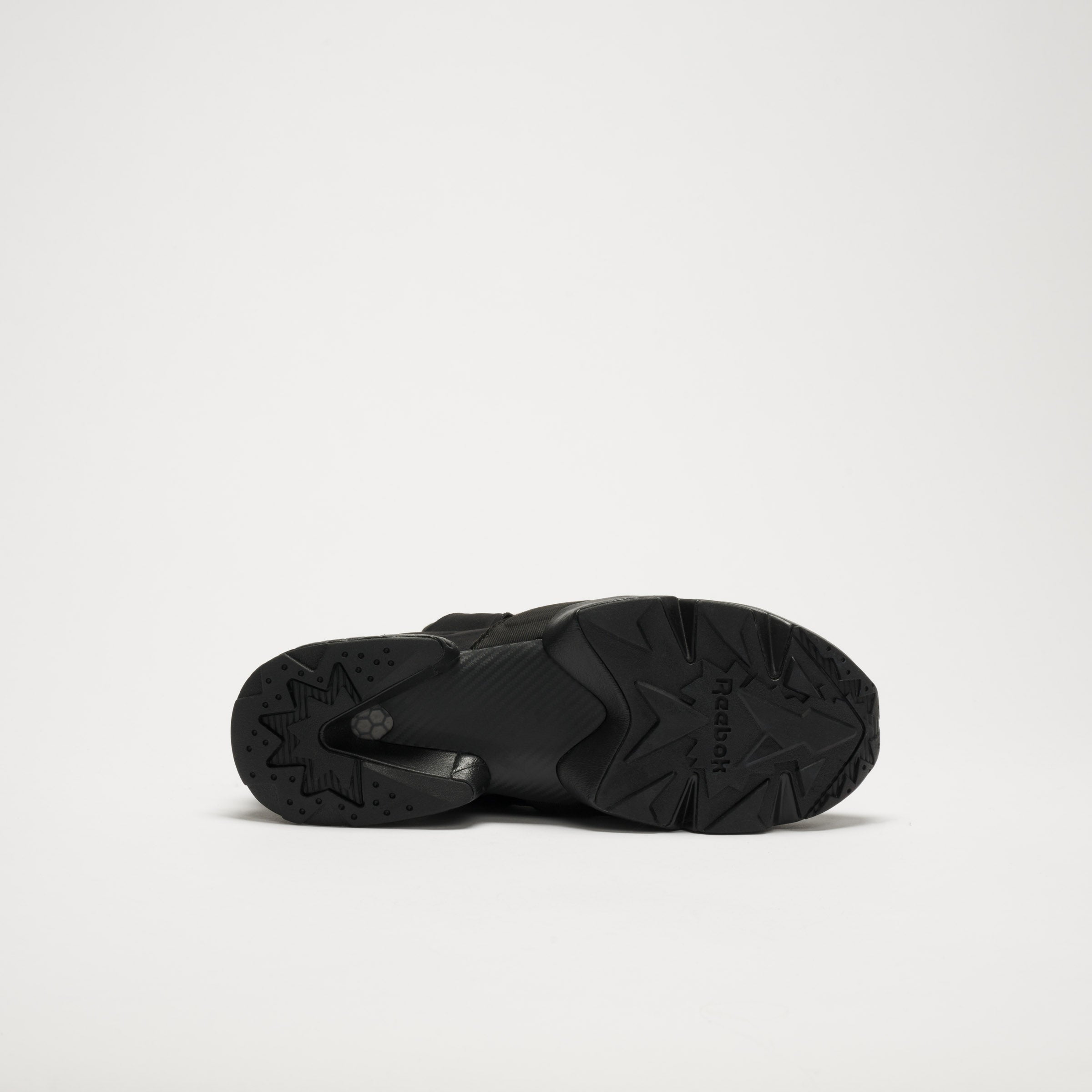 Bottom view of a single black Reebok Instapump Sliver LTD shoe with a chunky rubber sole, star-patterned tread, Hexalite cushioning, and the Reebok logo visible against a plain white background.