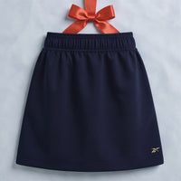 blue skirt on light blue background hanging from a red ribbon