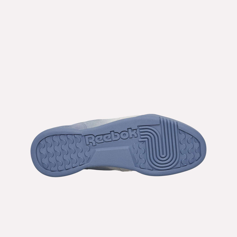 The image shows the bottom view of a sneaker with a blue rubber sole. The sole displays the Reebok logo and various textured patterns for grip, characteristic of classic retro silhouettes like the Reebok Workout Plus Og Shoes. The background is plain and light-colored.