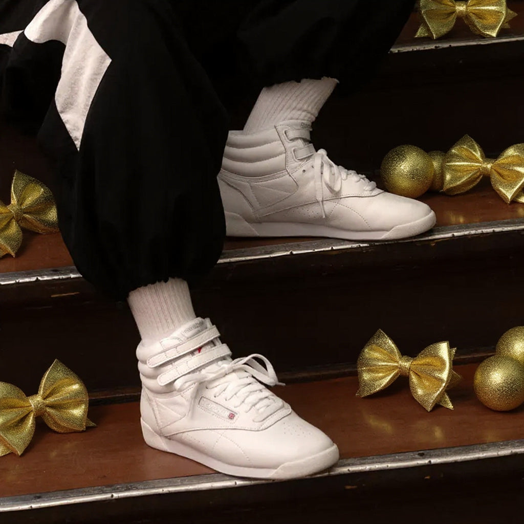 white sneakers on steps with gold bows