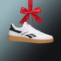 reebok white sneaker hanging from a red ribbon on medium blue background