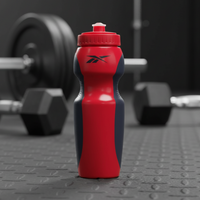 Red and black water bottle with Reebok logo on a gym floor with weights in the background