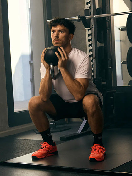 man in gym wearing orange shoes