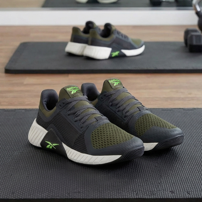 Green and Black Flip Charge Rebeok shoes on workout mat in gym