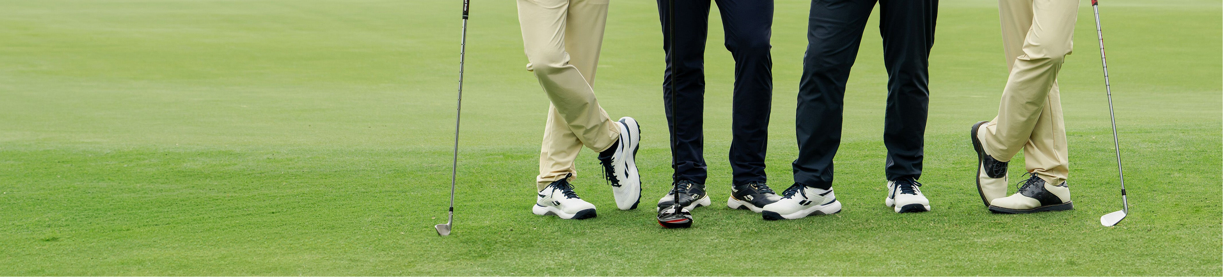 Four golfers on a green course with golf clubs and shoes visible