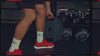 man working out in gym wearing red gym shoes