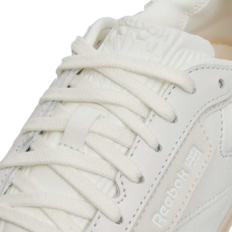 Close-up of the Reebok Club C LTD Shoes in white, highlighting laces, stitching, and the Reebok logo with a Union Jack. This classic lifestyle sneaker features smooth leather and a padded tongue, capturing timeless tennis-inspired style.