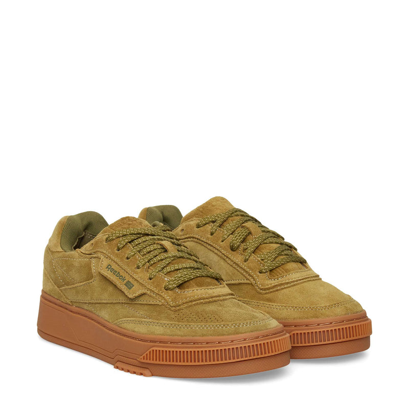 A pair of Reebok Club C LTD Shoes in tan suede with olive green laces and brown rubber soles, displayed side by side on a white background.