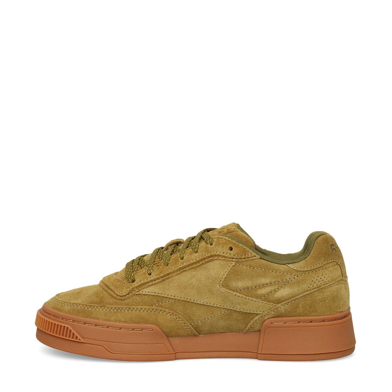 The Reebok Club C LTD Shoes feature tan suede with olive green accents and laces, a chunky textured light brown rubber sole, and are displayed in a left side profile on a white background—a lifestyle classic.