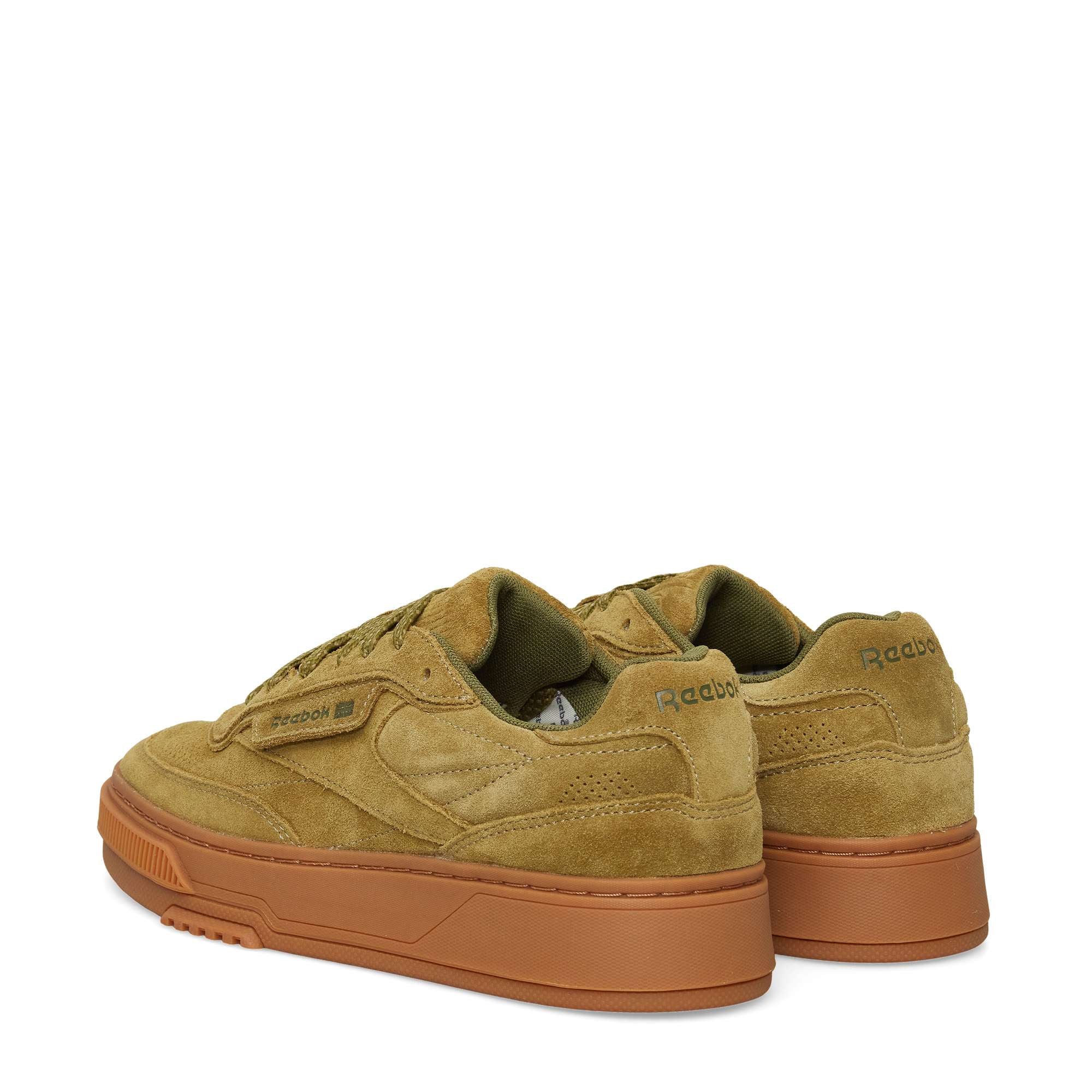 The Reebok Club C LTD Shoes in olive green suede feature dark green accents and chunky gum rubber soles, blending classic style with modern tennis-inspired details—shown from an angled rear view.