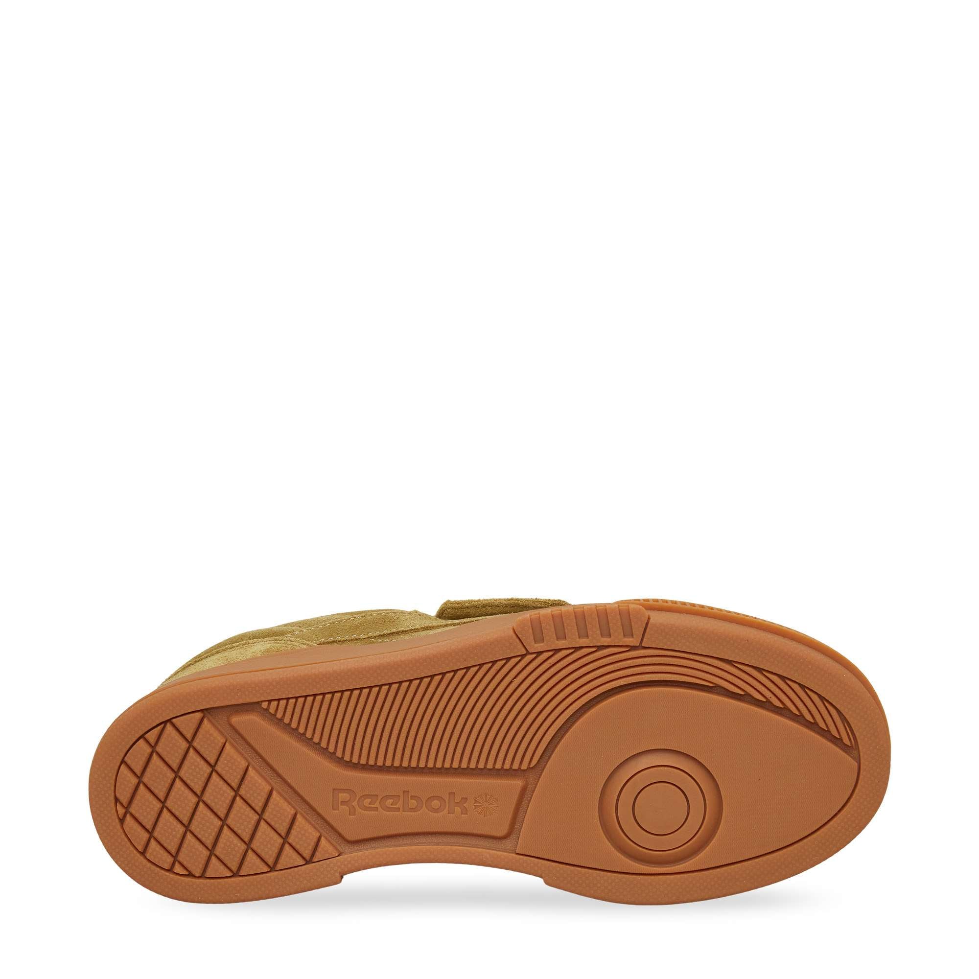 The image shows the bottom view of the Reebok Club C LTD Shoes in tan, featuring a textured rubber sole with a circular tread pattern and the Reebok logo near the arch—a true lifestyle classic.