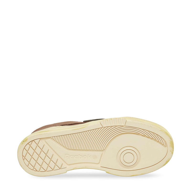 The image features the beige sole of a Reebok Club C LTD Shoe against a white background, showcasing its tread pattern and the embossed Reebok logo—a true lifestyle classic.