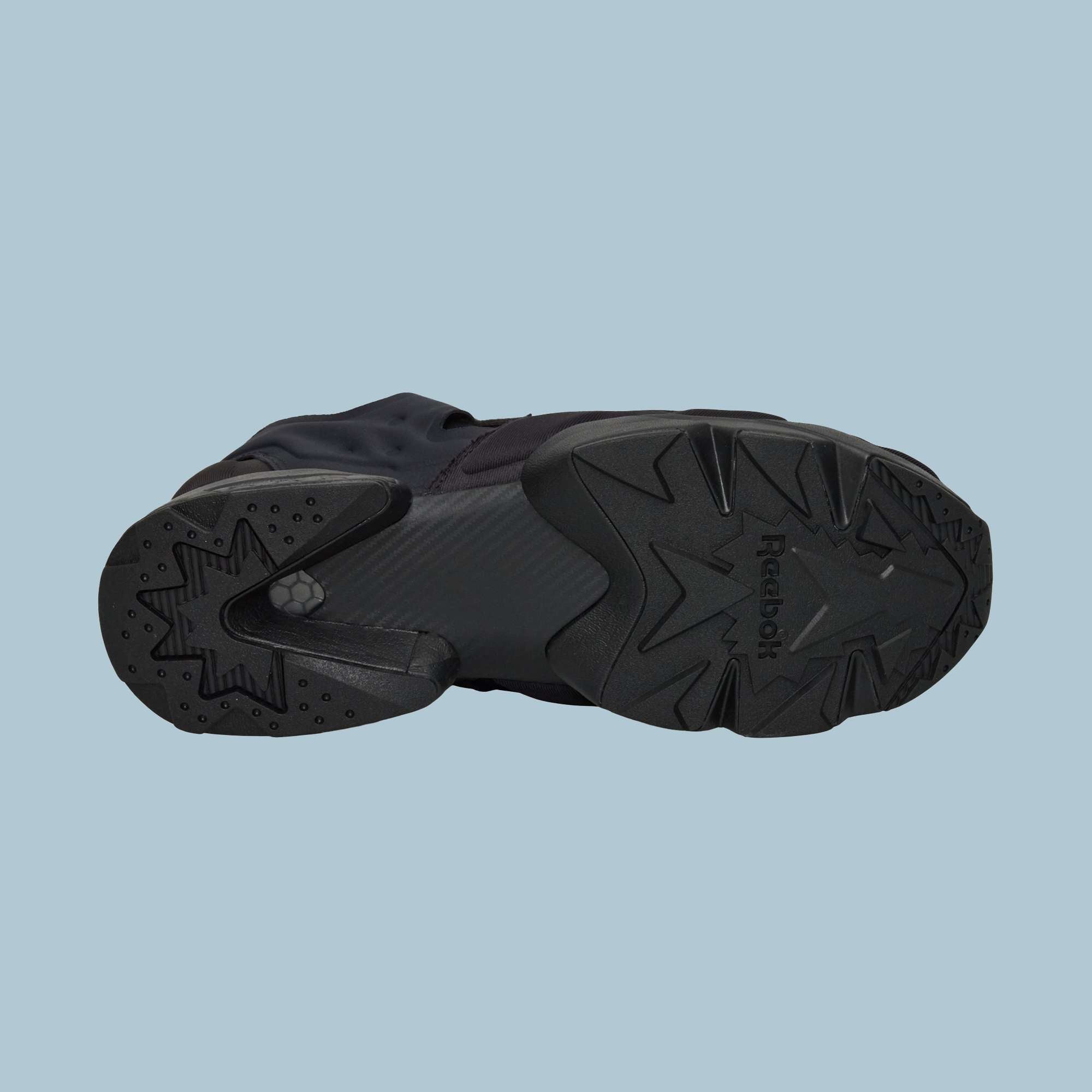 The Reebok Instapump Sliver Shoes are shown from the bottom on a light blue background, highlighting the sole’s textured patterns, Hexalite cushioning, and Reebok logo.