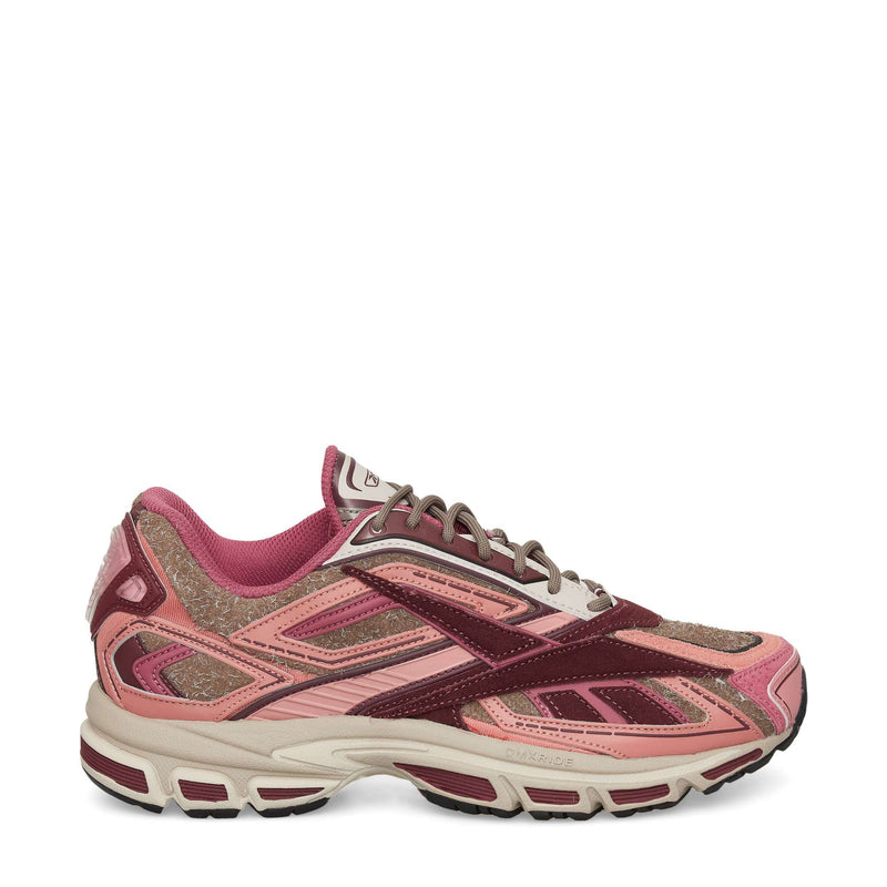 The Reebok Premier Road Ultra Shoes are stylish running sneakers in pink, burgundy, and light brown with mesh and suede uppers, a dual-density midsole, a white sole with dark accents, and a sporty, layered design.