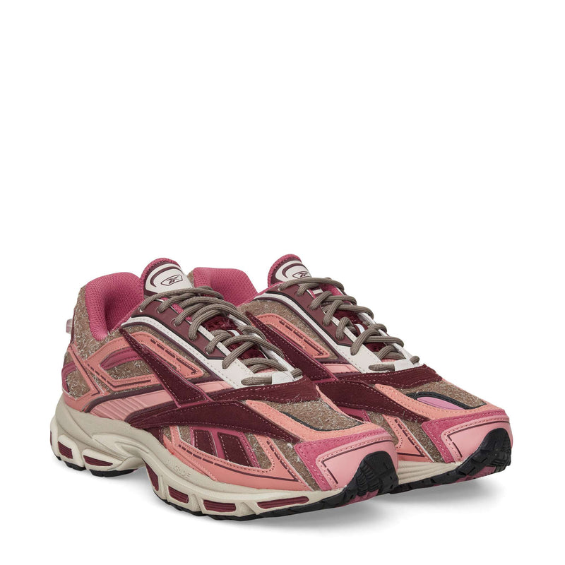 The Reebok Premier Road Ultra Shoes are stylish athletic sneakers in pink, burgundy, and beige with a chunky dual-density midsole, suede and mesh textures, intricate panels, and laces—perfect as modern running shoes.