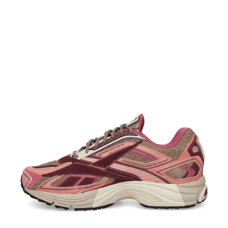 The Reebok Premier Road Ultra Shoes, shown from the side on a white background, are running sneakers in pink, maroon, and tan with mesh and suede uppers, a dual-density midsole, textured sole, and layered details.