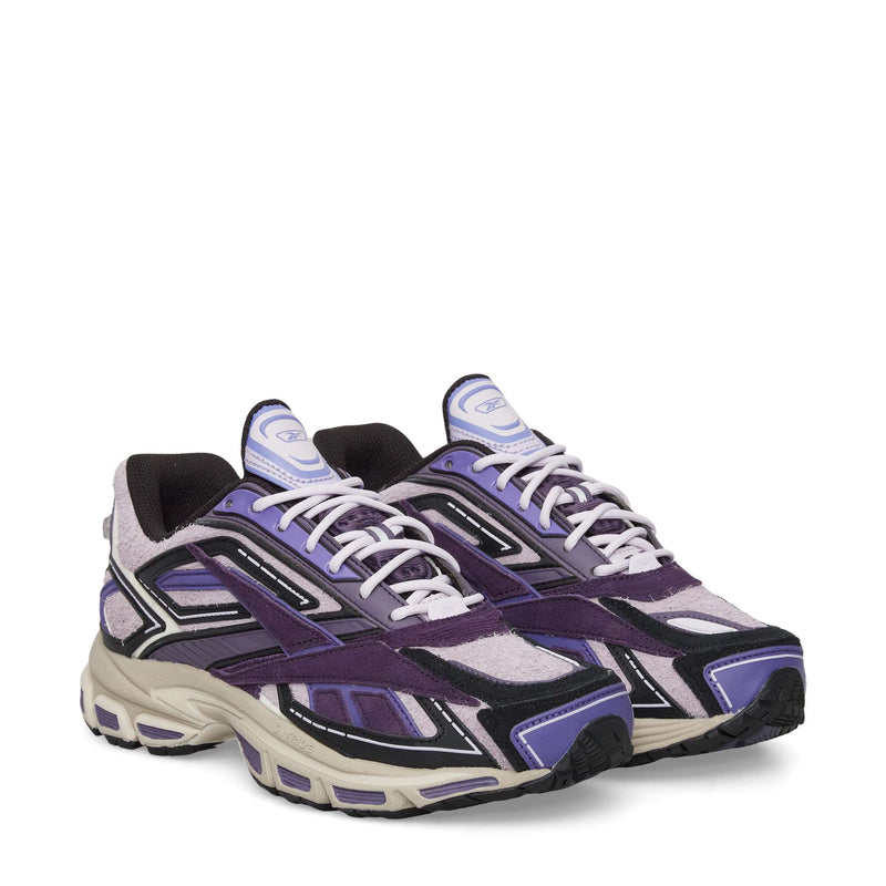 The image shows the Reebok Premier Road Ultra Shoes, featuring purple, black, and white suede and mesh uppers, white laces, and chunky beige dual-density soles. Both side and front views are displayed.