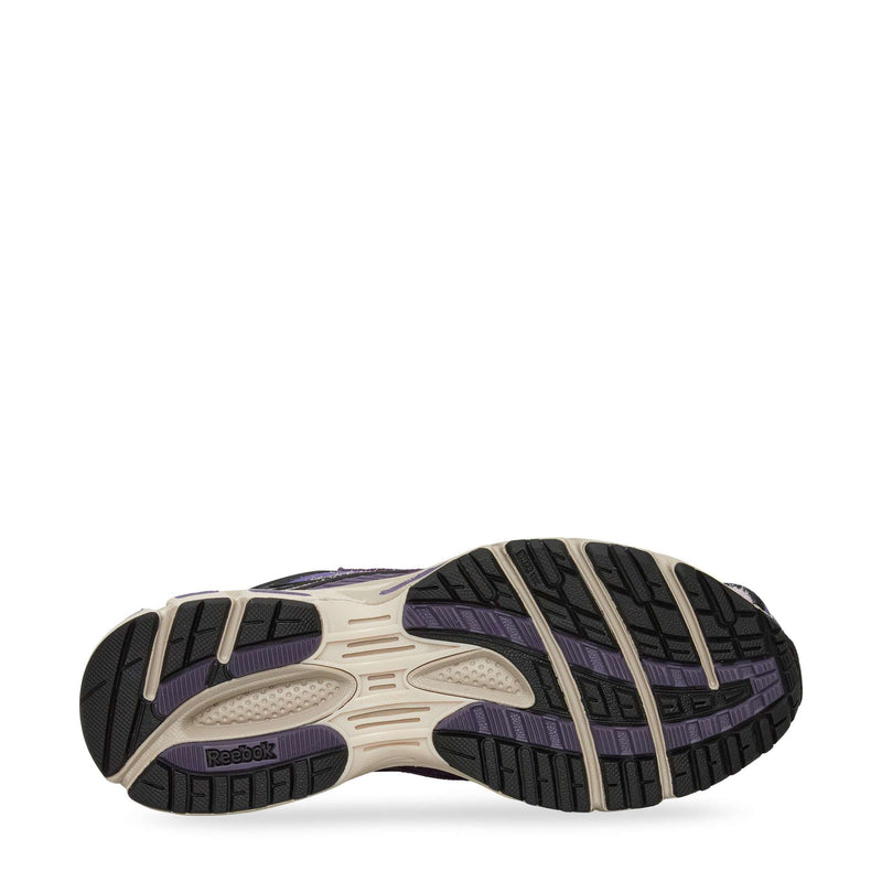 The image displays the sole of the Reebok Premier Road Ultra Shoes, with a patterned black and purple tread, cream accents, textured grip zones, and a visible Reebok logo near the heel.