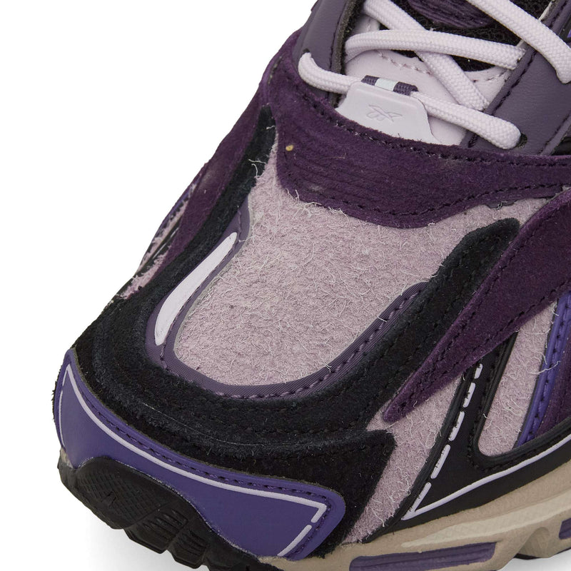 Close-up of the toe on Reebok Premier Road Ultra Shoes, highlighting textured and smooth purple, black, and beige materials, visible stitching, and part of the dual-density midsole.