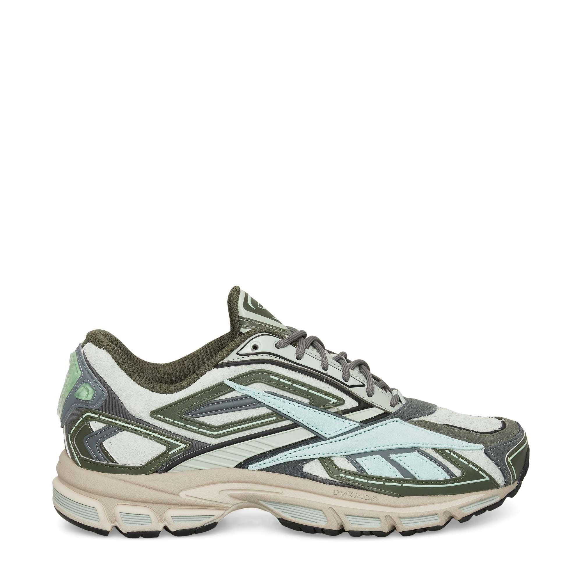 A stylish athletic sneaker featuring shades of green, beige, and light blue with layered overlays, mesh panels, a thick cushioned sole, and a lace-up closure, shown in a side profile on a white background.
