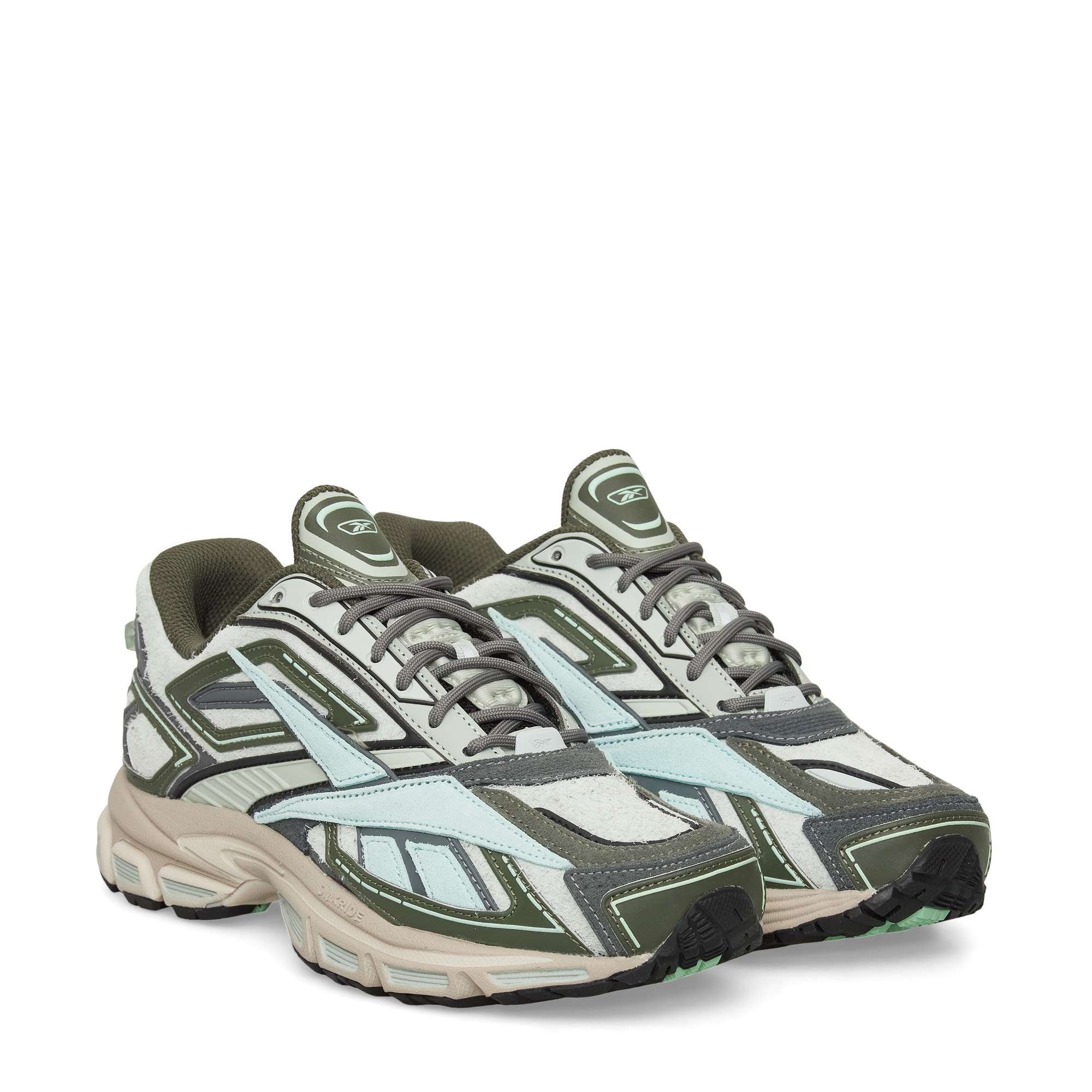 A pair of stylish athletic sneakers with a mix of olive green, light blue, beige, and gray panels, white midsoles, dark outsoles, and lace-up closures. The shoes feature a sporty, layered design.