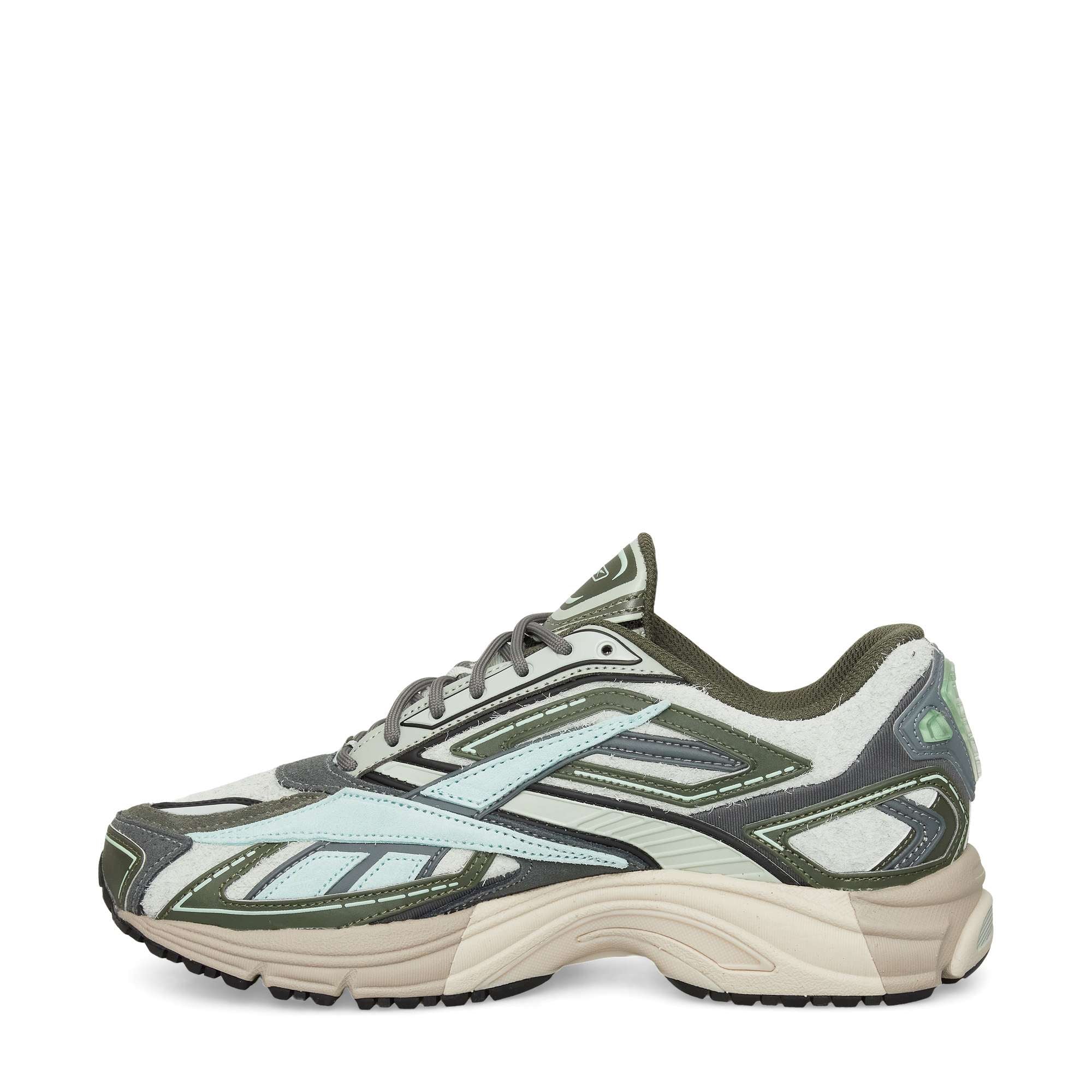 A green, white, and beige athletic sneaker with a chunky sole, mesh and suede details, and bold geometric patterns on the sides, viewed from the left side against a white background.