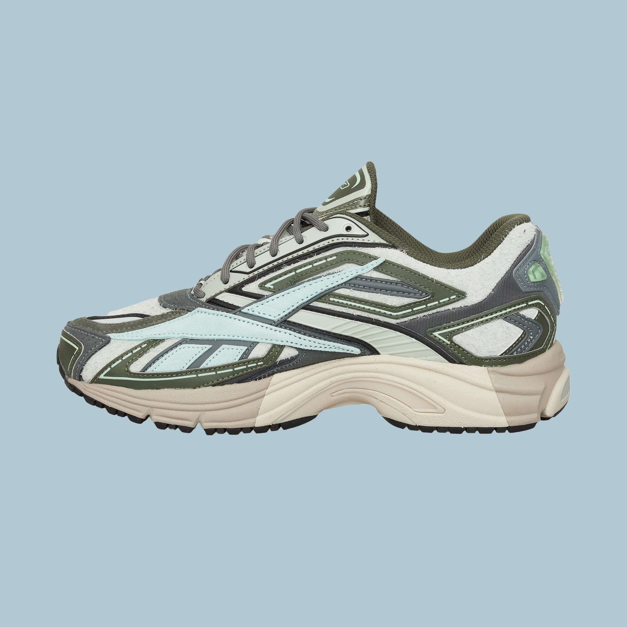 The Reebok Premier Road Ultra Shoes feature a beige sole, olive green and light blue upper, dual-density midsole, black accents, and grey laces, shown against a light blue background.