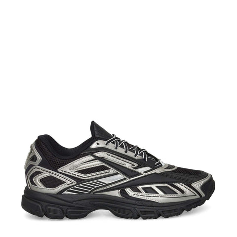 The Reebok Premier Road Ultra Shoes feature a black mesh upper with metallic silver accents, black laces, angular patterns, a chunky dual-density rubber sole, and boast a modern, sporty look.