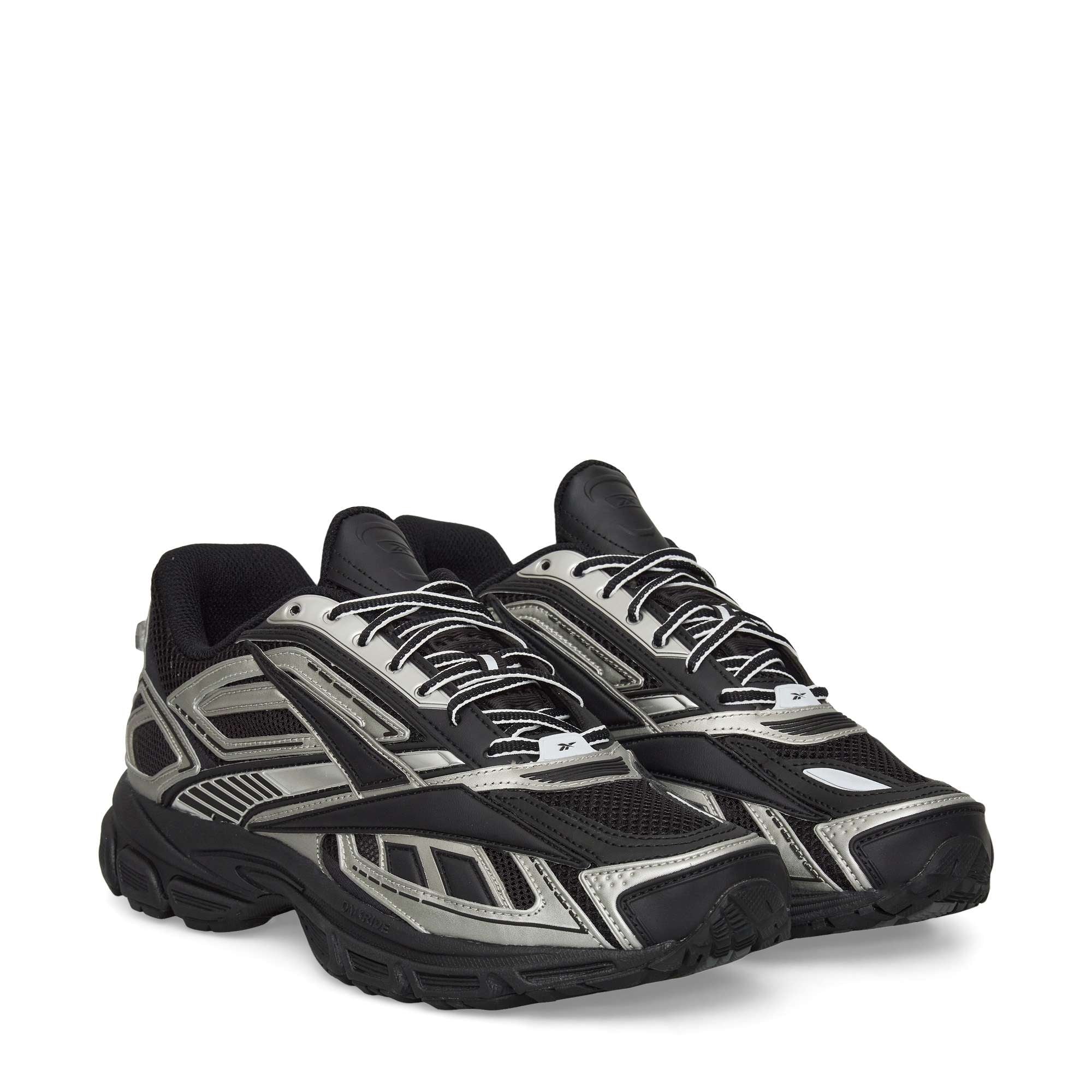 A pair of Reebok Premier Road Ultra Shoes in black and silver, featuring a chunky sole, mesh panels, dual-density midsole, and patterned overlays, displayed side by side angled slightly to the right.