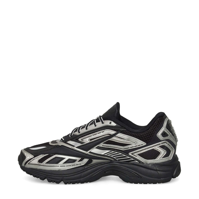 The Reebok Premier Road Ultra Shoes, shown from the side on a white background, feature a black mesh upper with silver accents, synthetic overlays in a layered design, and a chunky dual-density midsole for modern running style.