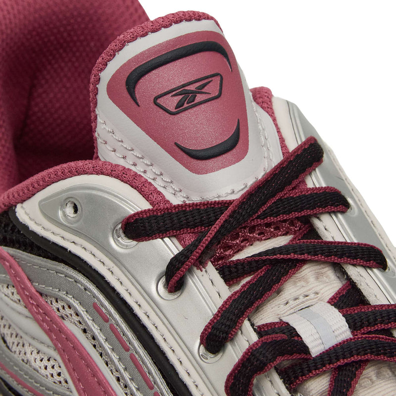 Close-up of Reebok Premier Road Ultra Shoes in white and pink, with black laces, mesh fabric, dual-density midsole, and silver-pink accents. Features the Reebok logo on the tongue.