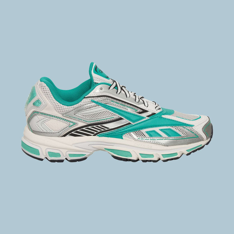 The Reebok Premier Road Ultra Shoes, shown in profile against a light blue background, feature white mesh uppers with teal and black accents and a thick dual-density midsole for an archival running silhouette.