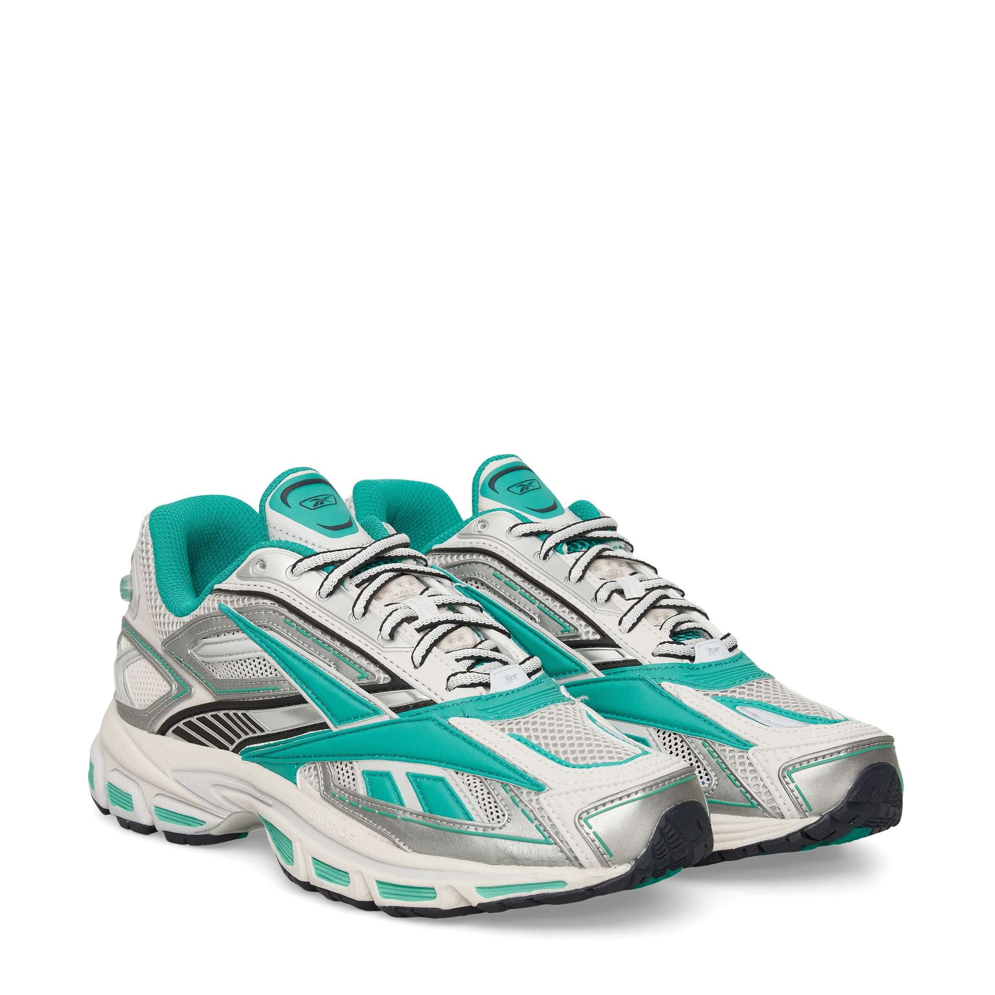 A pair of athletic sneakers with teal, silver, white, and black details, featuring mesh panels, teal Reebok logos, and chunky soles. The shoes are positioned side by side on a white background.