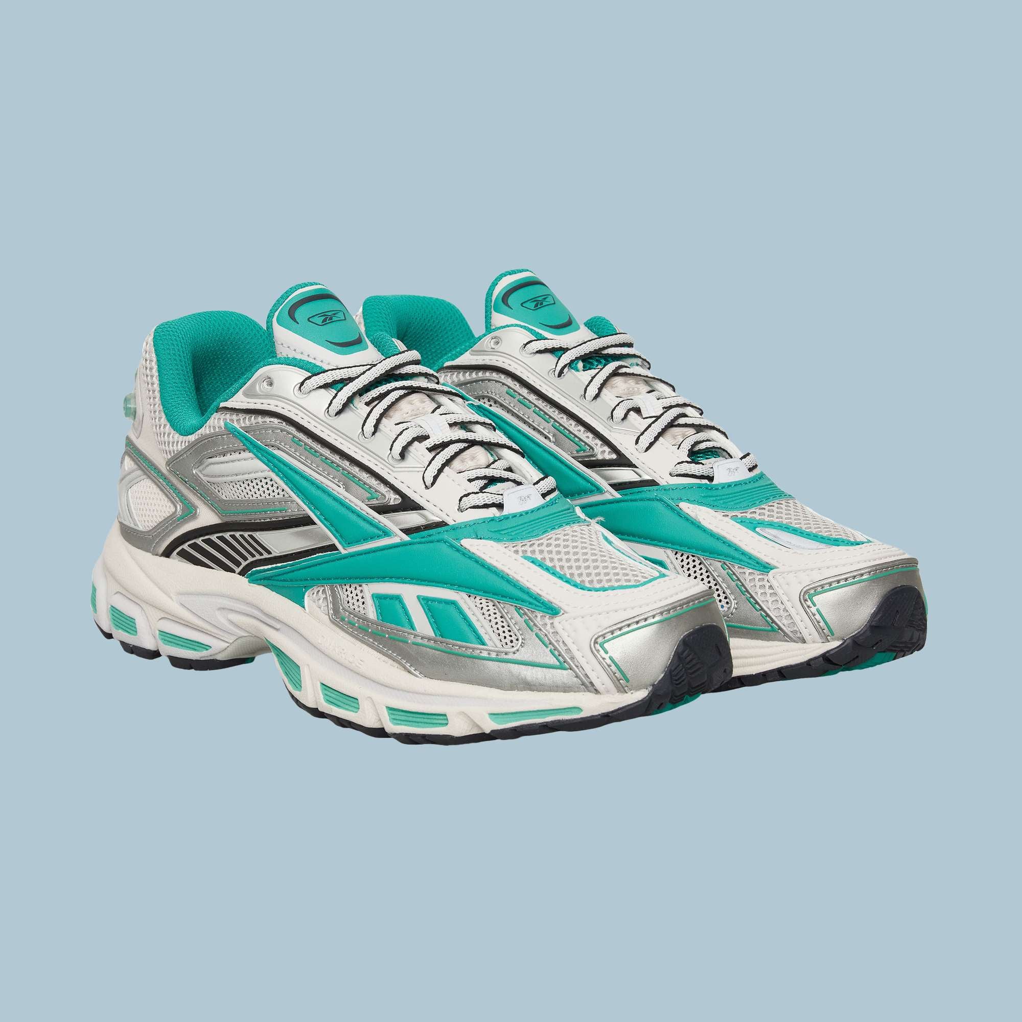 A pair of Reebok Premier Road Ultra Shoes in white and turquoise, with black and silver accents and a dual-density midsole, displayed on a light blue background.
