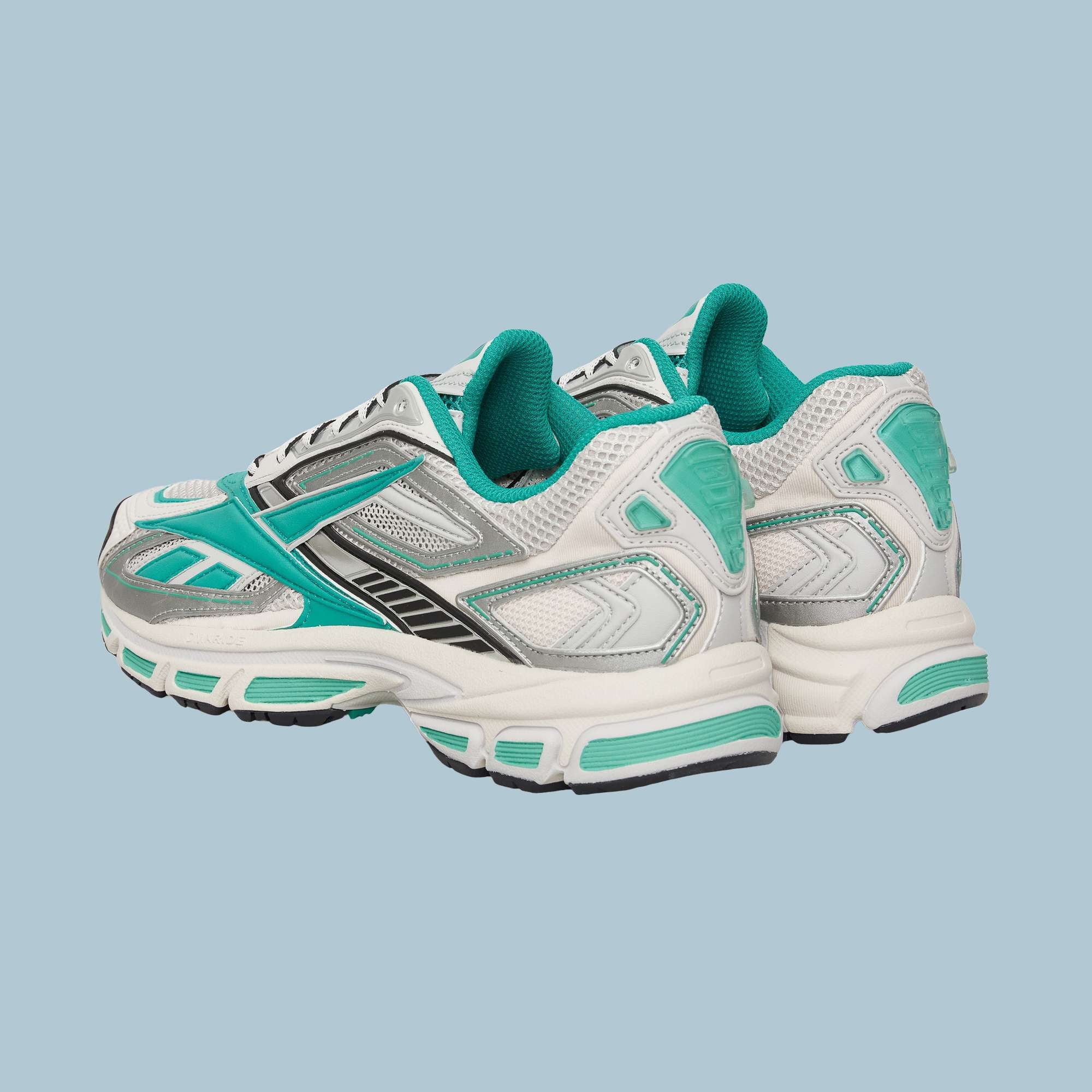 The Reebok Premier Road Ultra Shoes feature white uppers with teal and silver accents, black details, a dual-density midsole, and teal inner lining, shown on a light blue background.