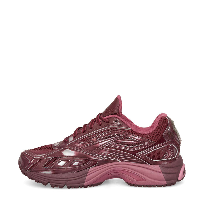The Reebok Premier Road Ultra Shoes are maroon running sneakers with mesh and synthetic overlays, dark and light pink accents, a textured sole, and a low-top design for comfort, shown in left side profile on a white background.
