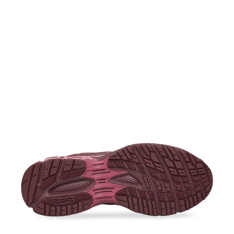 The image displays the bottom view of Reebok Premier Road Ultra Shoes, highlighting a maroon and pink treaded sole with textured grooves for comfort and stability, plus the Reebok logo near the heel.