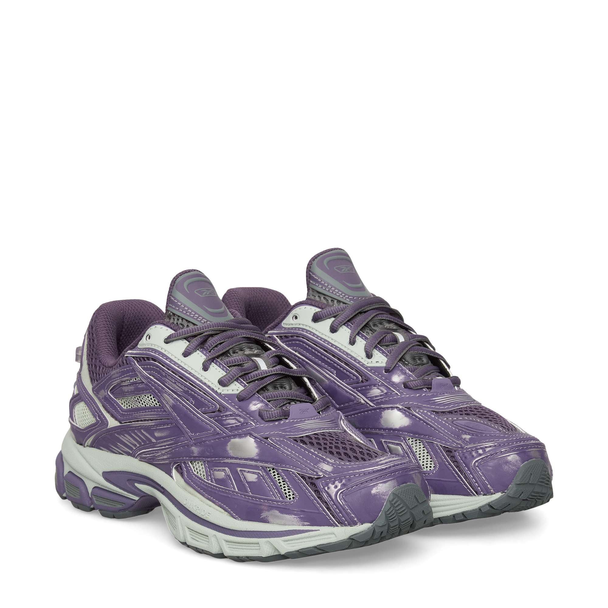 A pair of Reebok Premier Road Ultra Shoes in purple and gray with white laces, gray soles, a dual-density midsole, and a shiny finish is displayed on a plain white background.