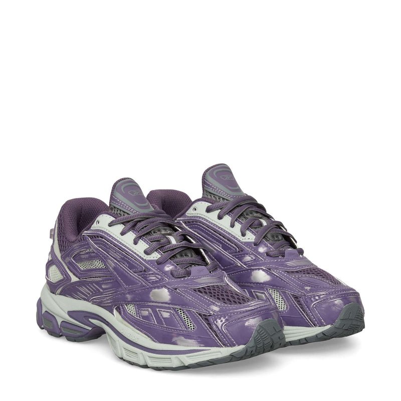 A pair of Reebok Premier Road Ultra Shoes in purple and gray with white laces, gray soles, a dual-density midsole, and a shiny finish is displayed on a plain white background.