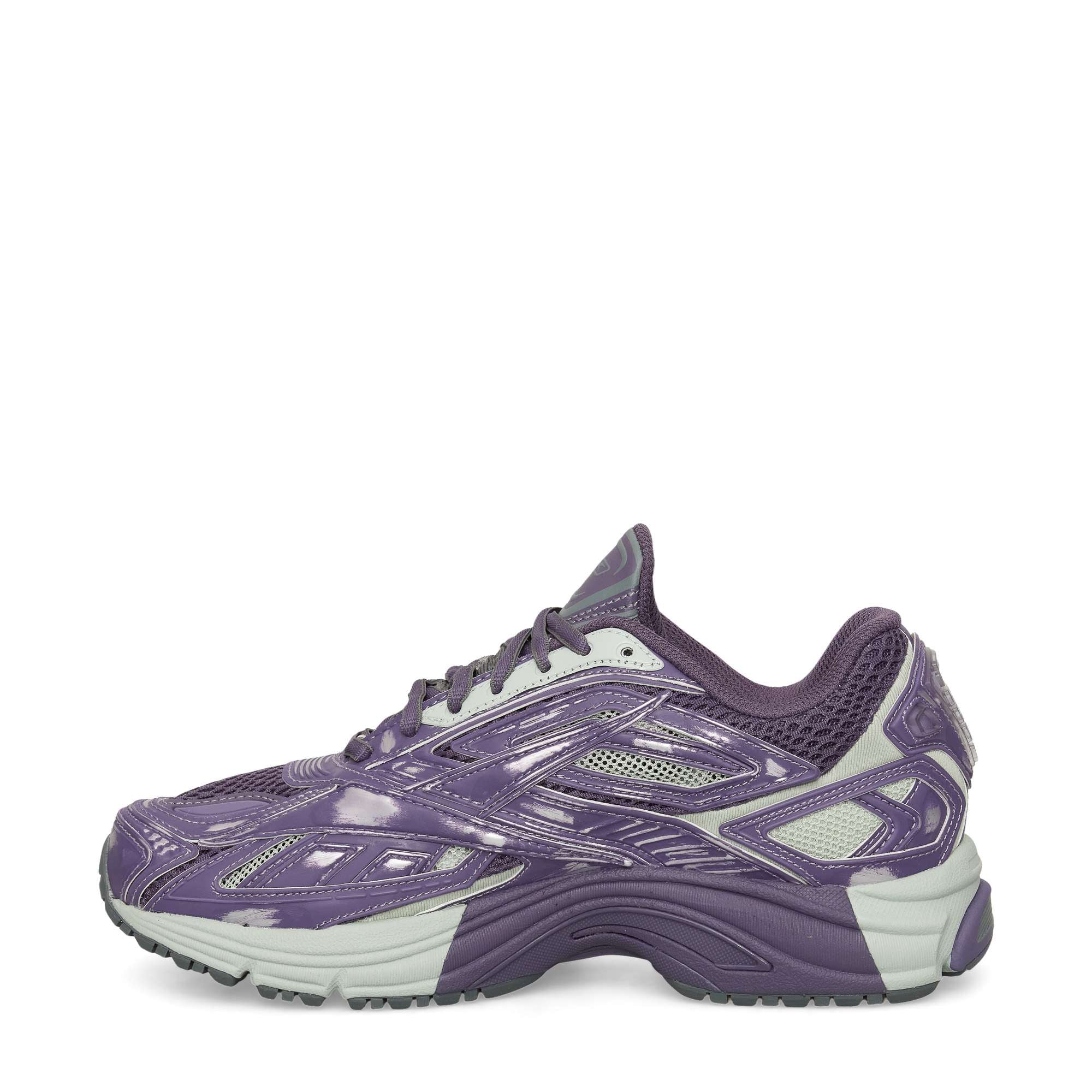 The Reebok Premier Road Ultra Shoes are shown in side profile on a white background, featuring purple and gray colors, a dual-density midsole, textured sole, and mesh details.