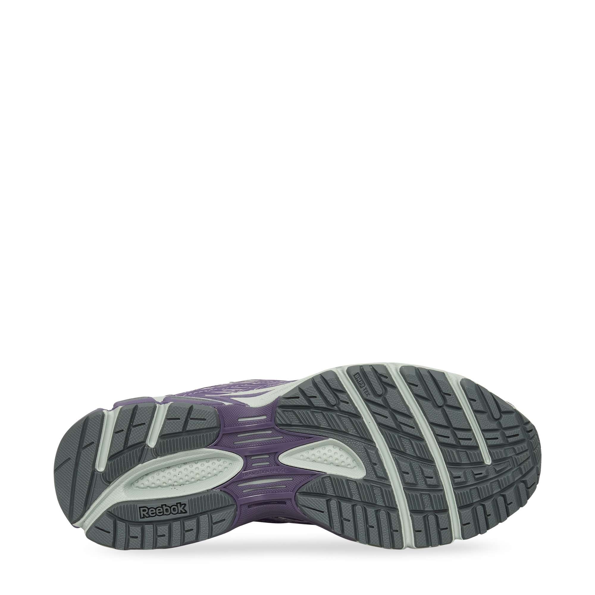 The image displays the outsole of the Reebok Premier Road Ultra Shoes, featuring a tread with dark gray, light gray, and purple sections for traction and support, as well as a dual-density midsole.
