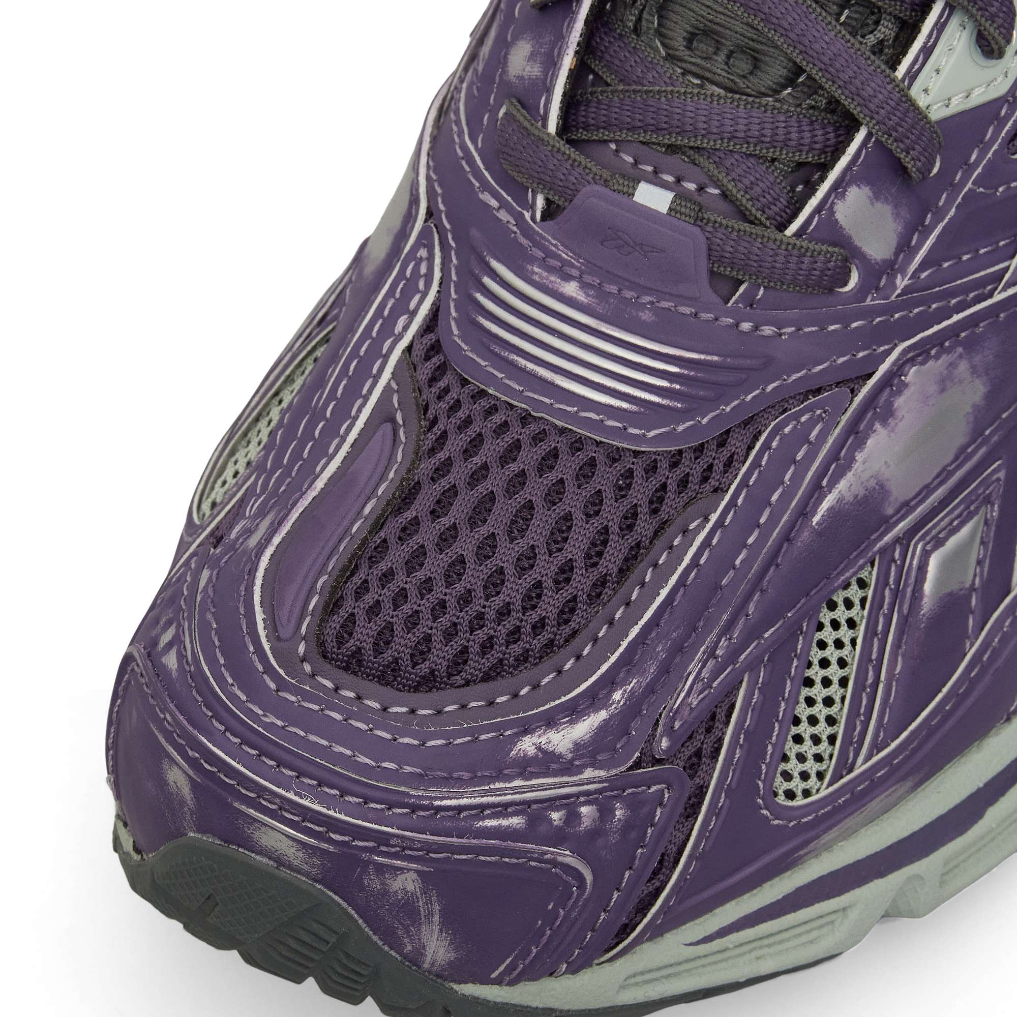Close-up of the Reebok Premier Road Ultra Shoes, showing shiny distressed purple leather, silver accents, mesh at the toe, dark purple laces, layered textures, and a modern dual-density midsole design.