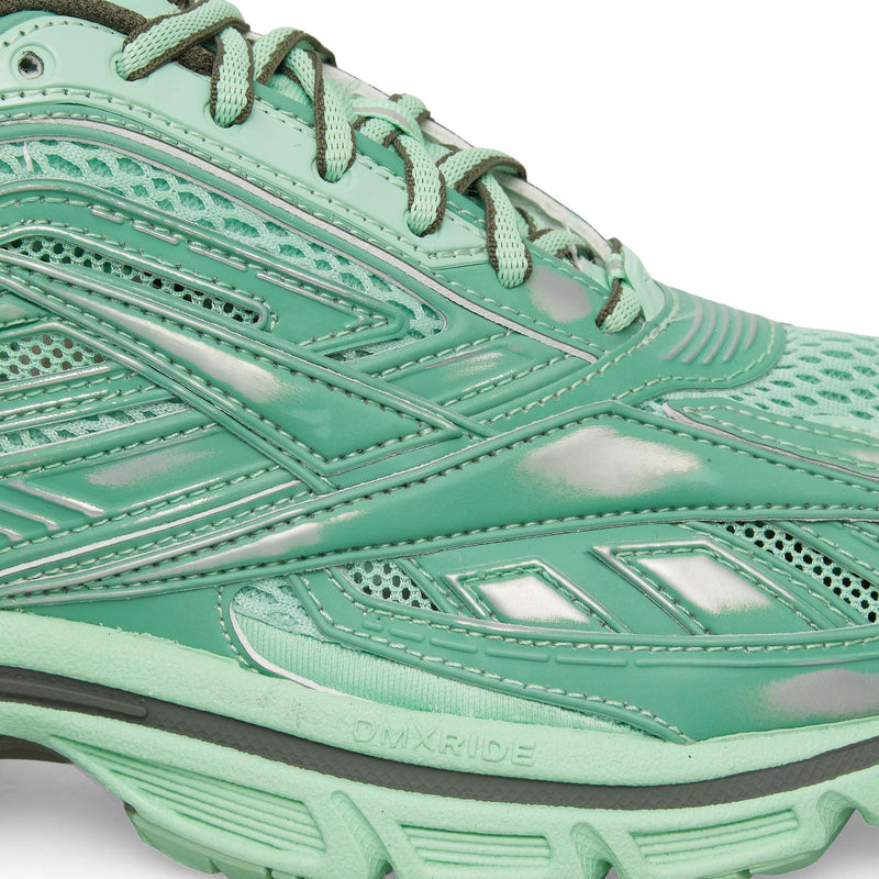 Close-up of Reebok Premier Road Ultra Shoes in green, featuring mesh and synthetic overlays, detailed stitching, DMXRIDE embossed on the sole, layered design accents, light green laces, and a dual-density midsole for comfort.
