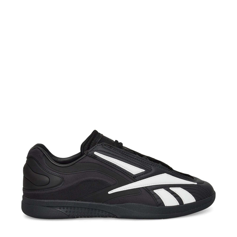 The Reebok Hammer Pro LTD Shoes, black faux leather low-tops with white stripes and a durable rubber sole, are shown in side profile against a plain white background.
