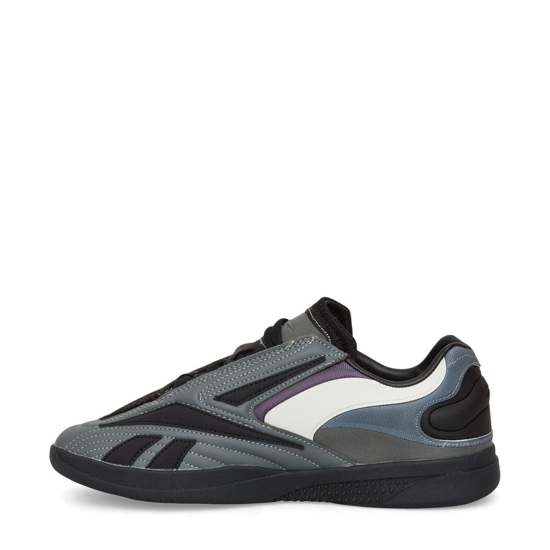 The Reebok Hammer Pro LTD Shoes are athletic sneakers in gray, black, and white with purple accents. They feature a sleek faux leather build, black sole, and layered panels. Shown in side profile on a white background.