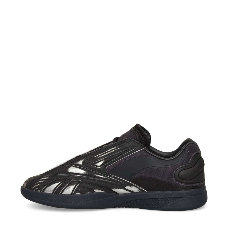 A black Reebok Hammer Pro LTD Shoe with a sleek low-top design, glossy faux leather upper, and durable rubber sole, shown side view on a white background.